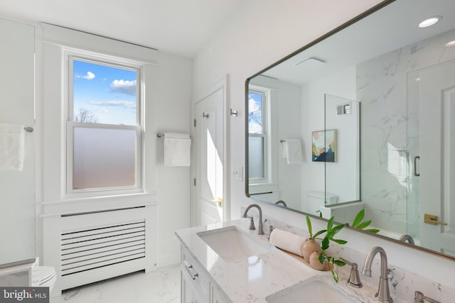 bathroom featuring toilet, marble finish floor, a sink, and a marble finish shower