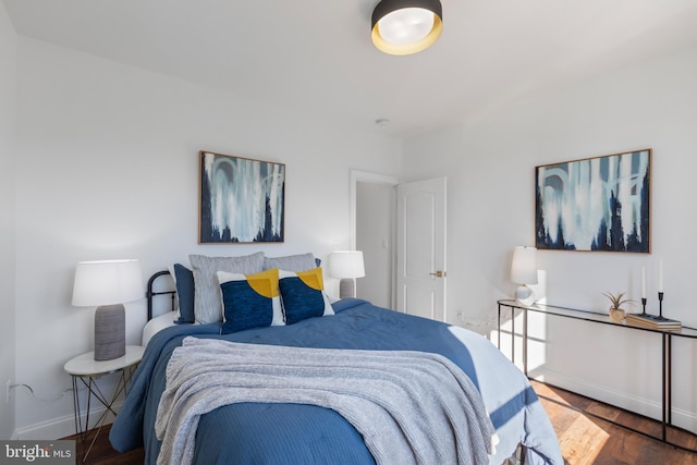 bedroom featuring wood finished floors and baseboards