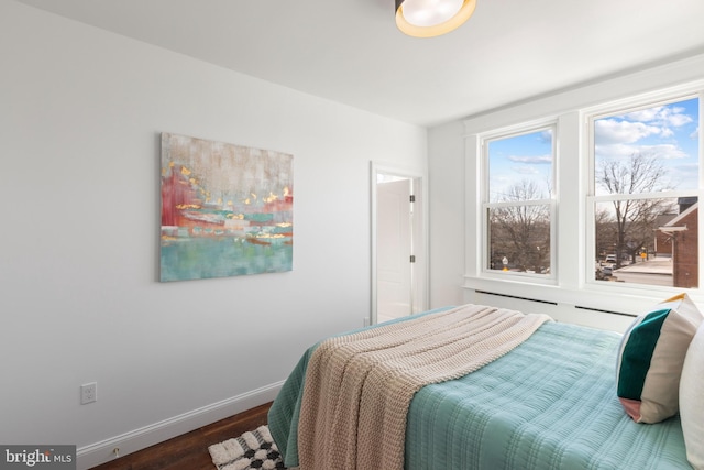 bedroom with baseboards and wood finished floors