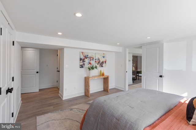 bedroom with baseboards, light wood-type flooring, and recessed lighting