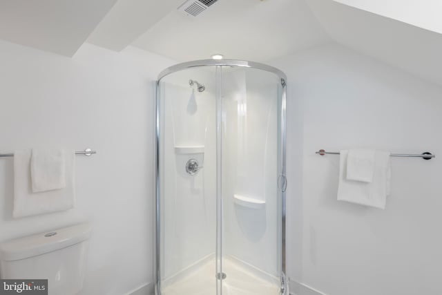 bathroom featuring toilet, a stall shower, lofted ceiling, and visible vents