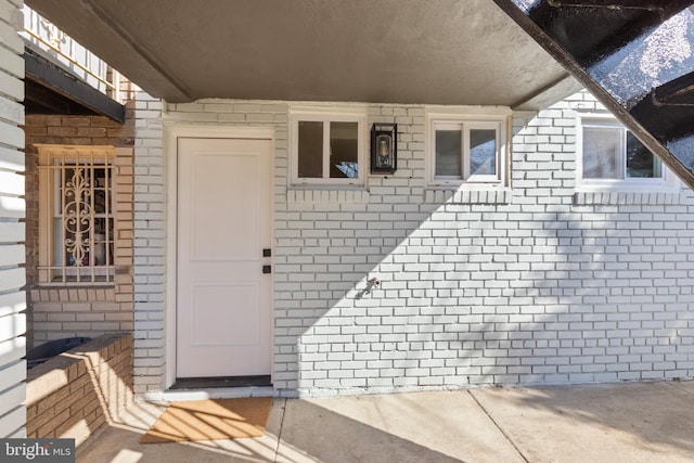 doorway to property with brick siding