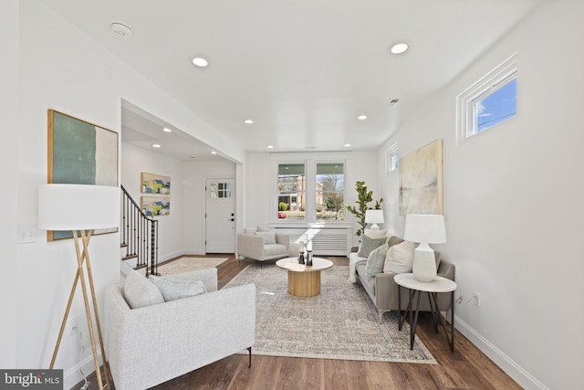 living area featuring baseboards, stairway, wood finished floors, and recessed lighting