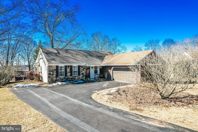 view of front of property with aphalt driveway, stone siding, and a garage