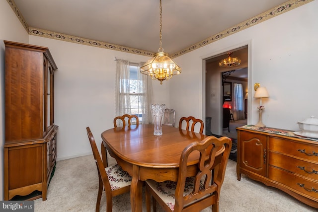 dining room with a chandelier and light colored carpet