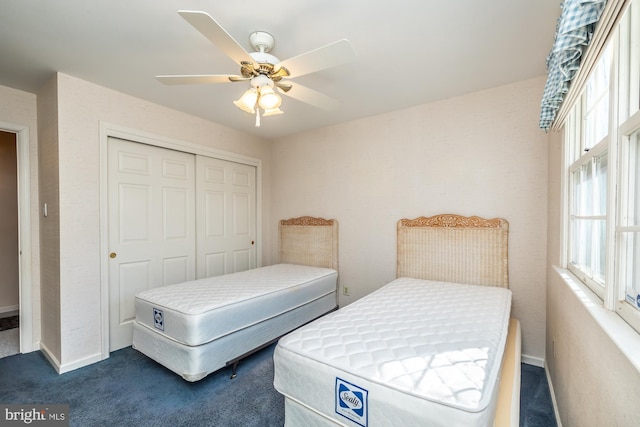 bedroom featuring ceiling fan, dark colored carpet, a closet, and baseboards