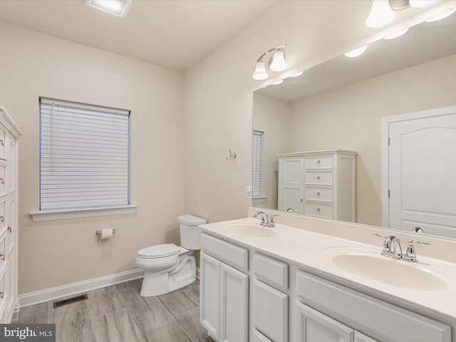 full bath with double vanity, baseboards, visible vents, and a sink