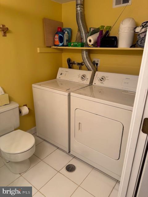 laundry room with laundry area, light tile patterned floors, and washer and clothes dryer