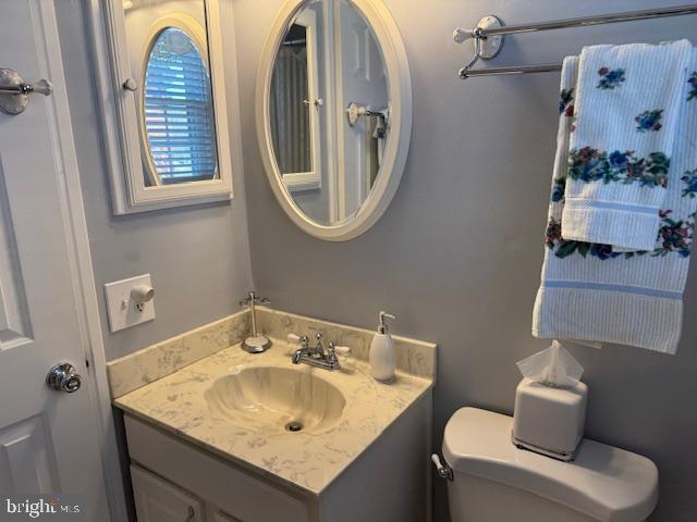 half bathroom with vanity and toilet