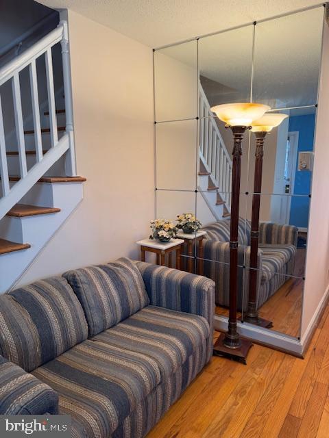 living area featuring stairway and wood finished floors