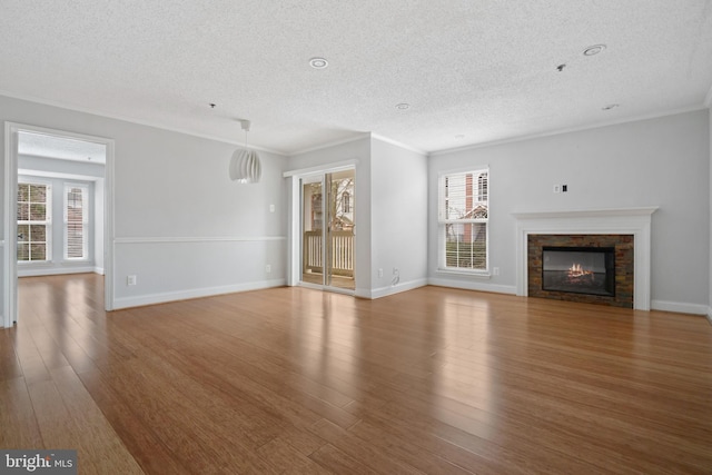 unfurnished living room featuring ornamental molding, wood finished floors, and a healthy amount of sunlight