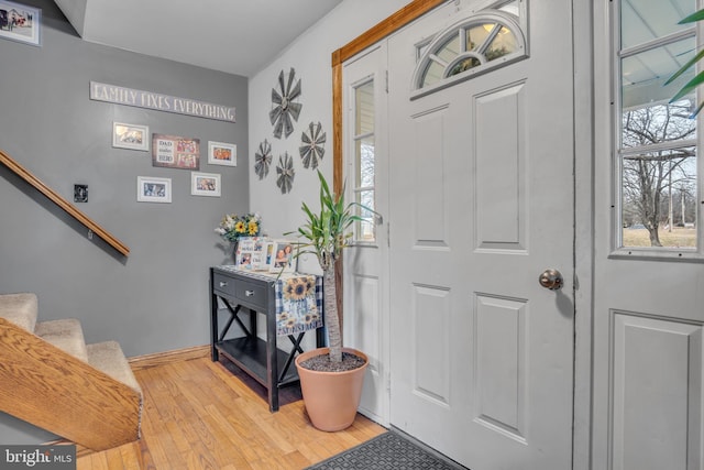 foyer featuring stairway, wood finished floors, and baseboards