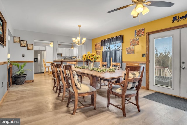 dining space with light wood finished floors and ceiling fan with notable chandelier