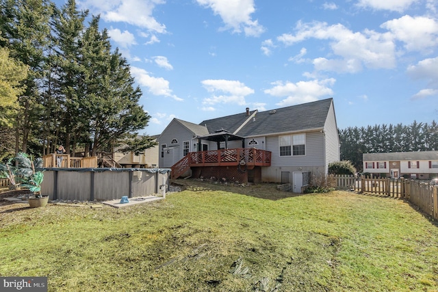 exterior space with an outdoor pool, a fenced backyard, a yard, and a wooden deck