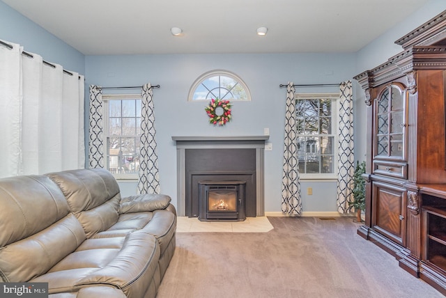 carpeted living area with a fireplace with flush hearth and baseboards