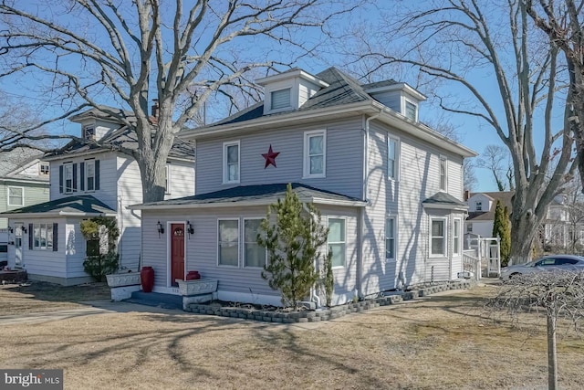 american foursquare style home with a front yard and entry steps