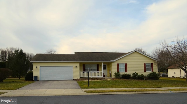 ranch-style house featuring a front yard, a porch, driveway, and an attached garage