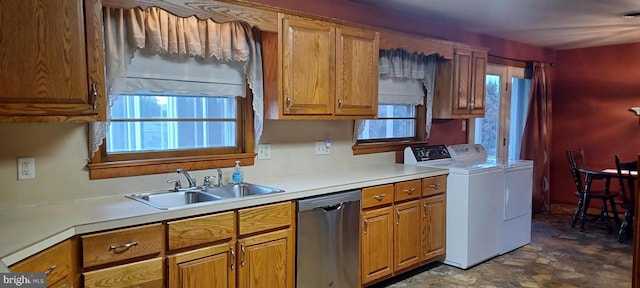 kitchen with a sink, brown cabinetry, stainless steel dishwasher, and independent washer and dryer