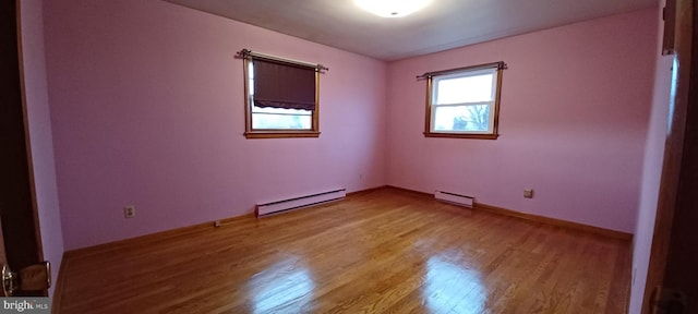 unfurnished room featuring baseboards, a baseboard heating unit, baseboard heating, and wood finished floors