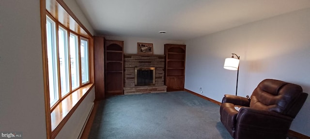 carpeted living area with built in shelves, baseboards, and a stone fireplace