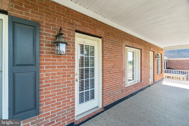 doorway to property with brick siding