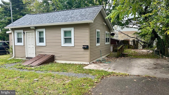 bungalow-style house featuring a shingled roof and a patio