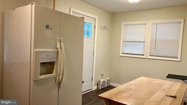 kitchen featuring dark wood-style floors, white refrigerator with ice dispenser, and baseboards