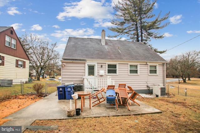 rear view of house featuring a chimney, central air condition unit, a shingled roof, a patio area, and fence