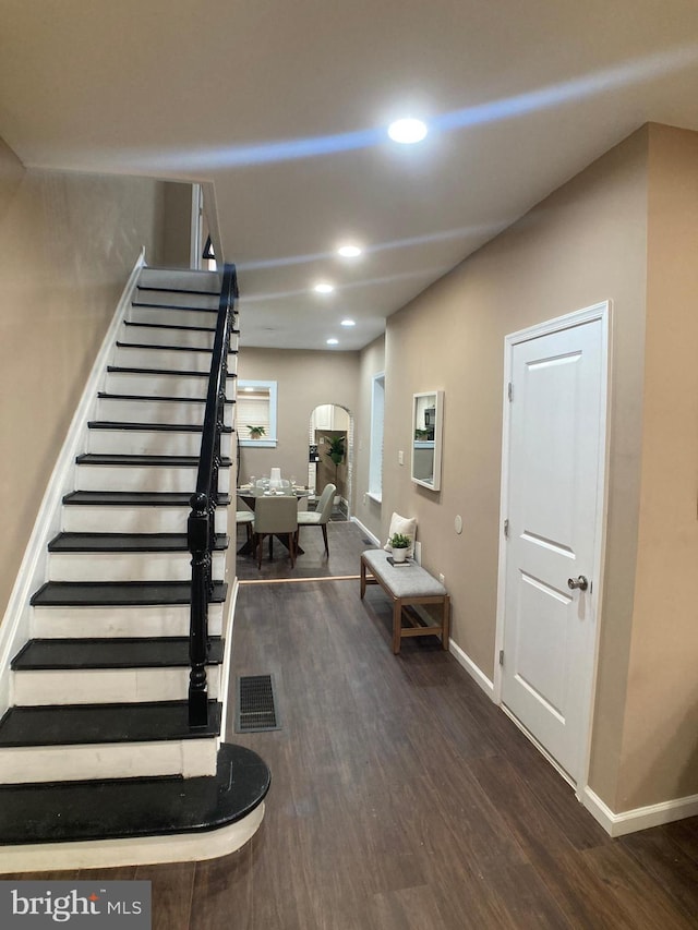 interior space with dark wood finished floors, recessed lighting, visible vents, baseboards, and stairs