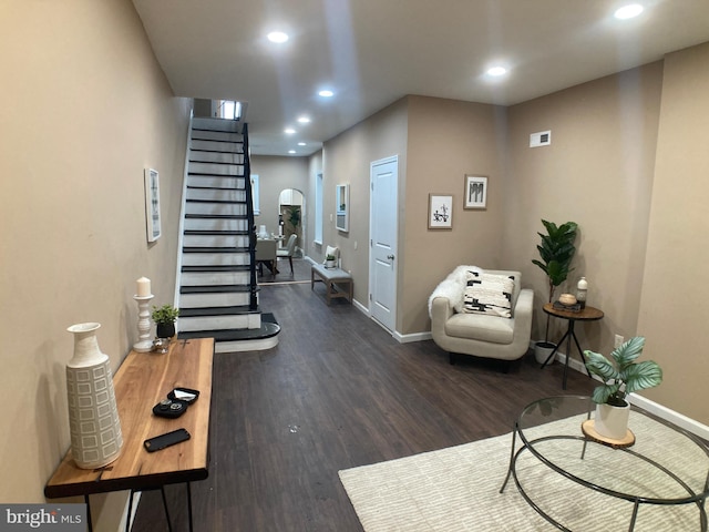 interior space with dark wood-style floors, stairs, arched walkways, and recessed lighting