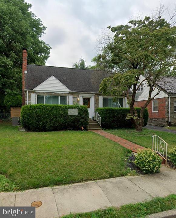 view of front of house featuring a chimney and a front lawn