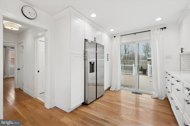 interior space featuring visible vents, decorative backsplash, wood finished floors, and recessed lighting