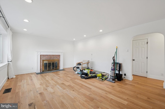 workout room featuring light wood-type flooring, a fireplace, visible vents, and recessed lighting