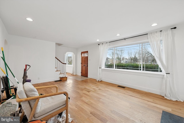 living area with light wood finished floors, baseboards, visible vents, stairway, and recessed lighting