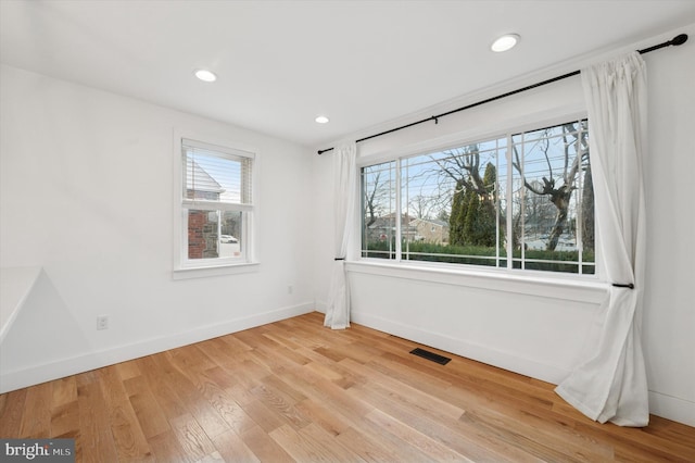 unfurnished room with light wood-style flooring, recessed lighting, visible vents, and baseboards