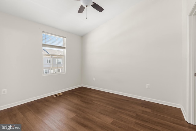 spare room featuring baseboards, visible vents, dark wood finished floors, and a ceiling fan