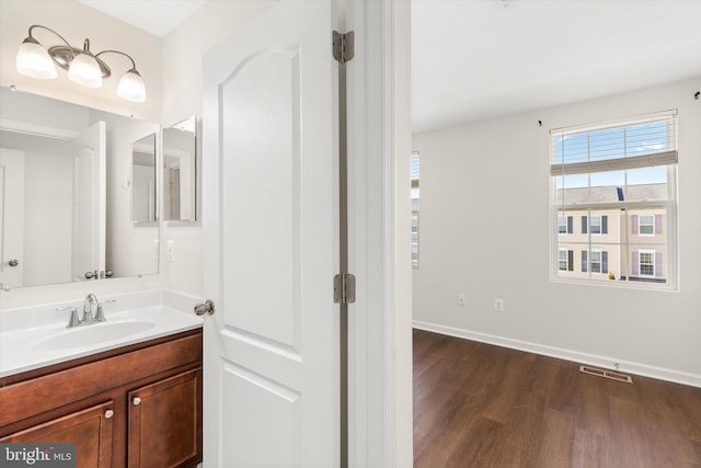 bathroom featuring vanity, wood finished floors, visible vents, and baseboards