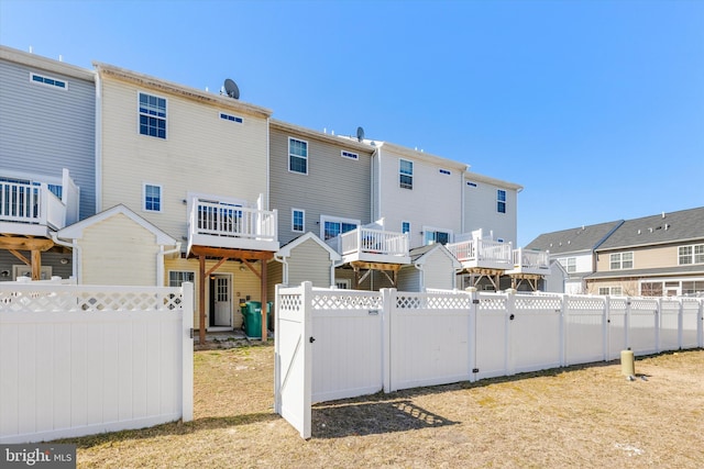 rear view of property featuring a fenced backyard and a residential view