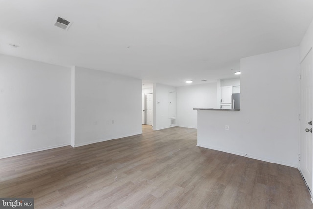 unfurnished living room with recessed lighting, baseboards, visible vents, and light wood finished floors