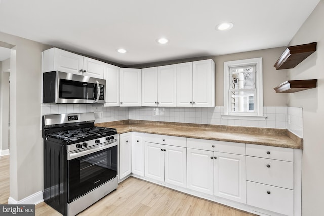 kitchen featuring tasteful backsplash, appliances with stainless steel finishes, and white cabinets