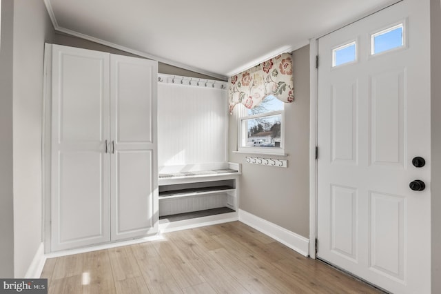 interior space with light wood-type flooring, baseboards, and vaulted ceiling