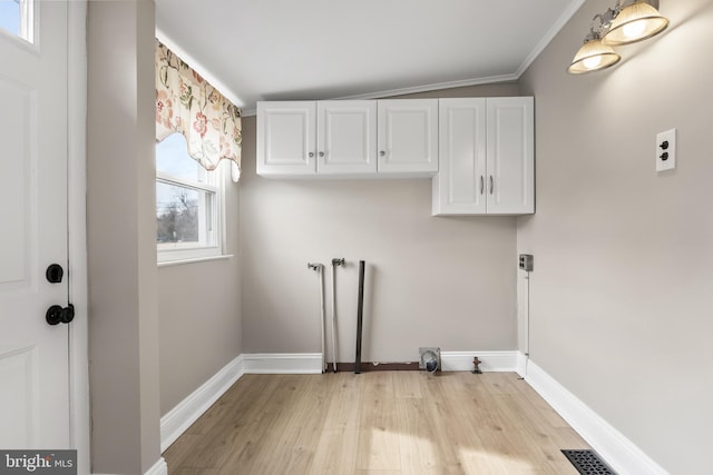 clothes washing area with cabinet space, visible vents, light wood-style floors, hookup for an electric dryer, and baseboards