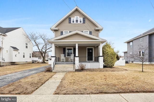 view of front of home with a porch and a front lawn