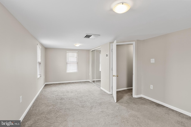 interior space with visible vents, light carpet, and baseboards