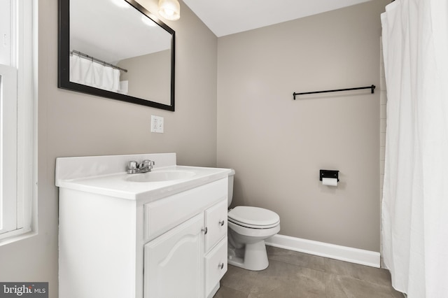 bathroom with toilet, tile patterned flooring, vanity, and baseboards