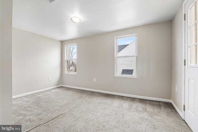 carpeted spare room with plenty of natural light and baseboards