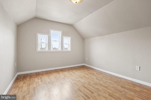 bonus room with lofted ceiling, baseboards, and light wood-style floors