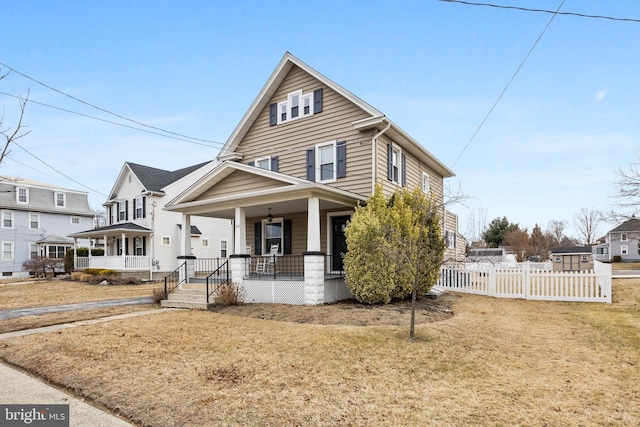 view of front of house featuring a porch, fence, and a front lawn