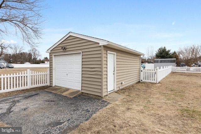 detached garage with driveway and fence