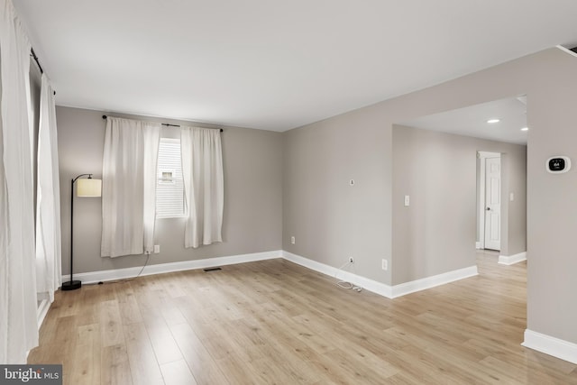 empty room featuring light wood-style floors, recessed lighting, and baseboards